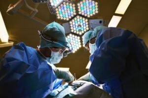 Surgeons performing operation under bright lights; crucial queries for selecting a thyroid surgeon.